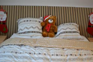 un osito de peluche sentado encima de una cama en Rivière, en La Celle-sous-Gouzon