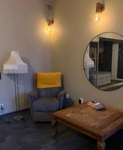 een woonkamer met een tafel, een stoel en een spiegel bij Helsingebockens Fastigheter 