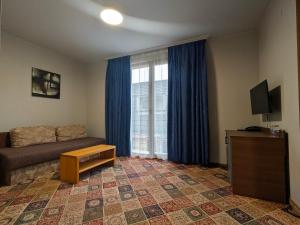 a living room with a couch and a large window at Hotel La Roka in Stara Zagora