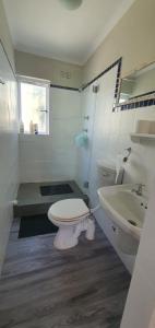 un baño con inodoro y lavabo en Sufi'Sawd Guest Rooms Muizenberg, en Muizenberg