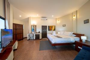 a bedroom with a bed and a flat screen tv at Chaweng Bay View Resort by Smith & Appy in Ko Samui