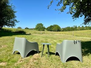 two chairs and a table in a field at Luxe tent met rust, ruimte en uitzicht in Saint-Sulpice-dʼExcideuil