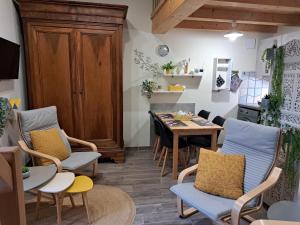 a room with a table and chairs and a kitchen at La Métairie au milieu des vignes in Réaux