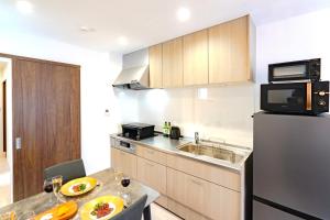 a small kitchen with a sink and a refrigerator at sunshin dream in Osaka