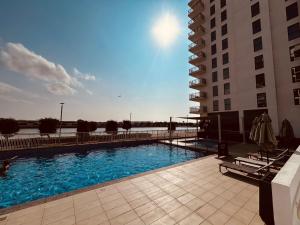 ein Schwimmbad vor einem Gebäude in der Unterkunft ARK Luxury Rooms walking Distance to Ferrari world, Yas Island in Yas Island