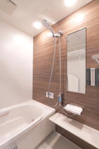 a bathroom with a bath tub and a shower at sunshin dream in Osaka +15 photos