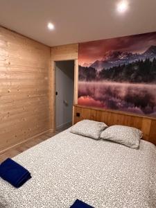 a bedroom with a bed and a painting on the wall at Loft-chalet 12 pers - Billiards - Cinéma - 10 min ski in La Cabanasse