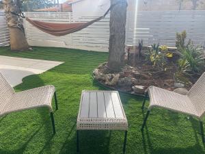a patio with two chairs and a table and a tree at Ramon Palms in Mitzpe Ramon +11 photos