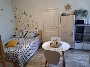 a small bedroom with a bed and a table and chairs at La Métairie au milieu des vignes in Réaux