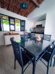 einen Esstisch mit Stühlen in der Küche in der Unterkunft Casa da Vó Rita - praia do Cumbuco in Caucaia