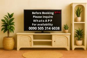 una TV su uno scaffale in una stanza con delle piante di Charming Villa with Swimming Pool a Foça