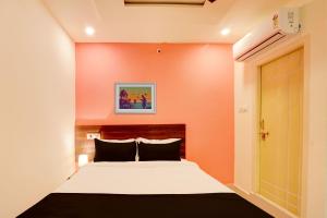 um quarto com uma cama com uma parede laranja em Hotel O S L N Grand em Upal