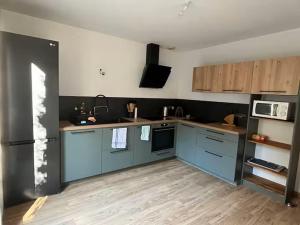 a kitchen with blue cabinets and a microwave at Le refuge de la fée in Fellering