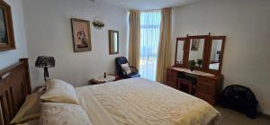 een slaapkamer met een bed, een wastafel en een spiegel bij Albatros 106 in Amanzimtoti