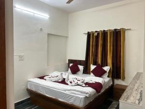 浦那Hotel Royal Inn的卧室里有一张床，上面有红色和白色的枕头