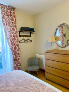a bedroom with a bed and a mirror and a chair at Newly Renovated Ground Floor Apartment close to Thermes in Luchon