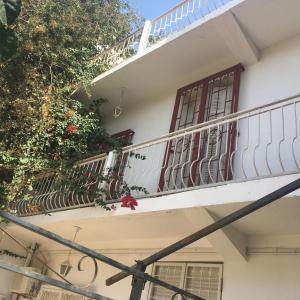 un edificio blanco con un balcón con flores. en Maison de Sila, en Bir el Djir