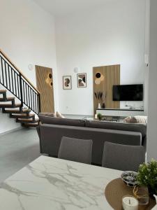 een woonkamer met banken, een tv en een trap bij Apartment Agnes in Vlorë