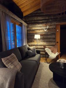 un soggiorno con divano in una parete di tronchi di Kelo Naava a Ruka