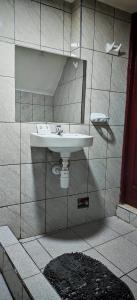 uma casa de banho com um lavatório numa parede em azulejo em hawka pacha cusqueña em Cusco