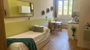 een kleine kamer met een bed en een tafel. bij Dina chic calme cosy in Saint Etienne +8 foto's