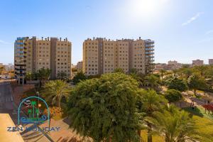 two tall buildings in a city with palm trees at 3 Bed 2 Bath Apartment Los Pinos in El Campello