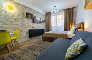 古多里New Gudauri - Feel Like a Kid - Cozy Apartment的一间酒店房间，里面有一张床和一张沙发