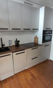 Somnium2 في بلانكنبرخ: مطبخ بدولاب بيضاء وموقد اسود +صورتان