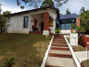 a small white house with stairs leading to it at Bosque Macadamia in El Tejar