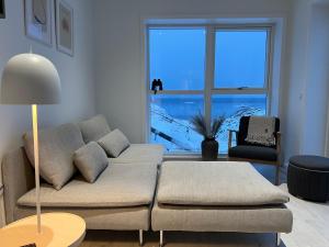 Una sala de estar con un sofá y una ventana grande. en Private apartment with panoramic ocean views, en Ilulissat 11 fotos más