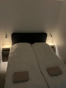 um quarto com uma cama branca com duas mesas de cabeceira em Private apartment with panoramic ocean views em Ilulissat mais 10 fotografias