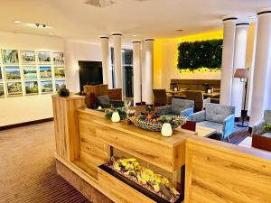 a lobby with a fireplace in the middle of a room at AMBER HOTEL Bavaria in Bad Reichenhall