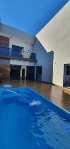 a large blue swimming pool in an empty room at Casa de Alto Padrão com 5 Suítes e Piscina in Foz do Iguaçu