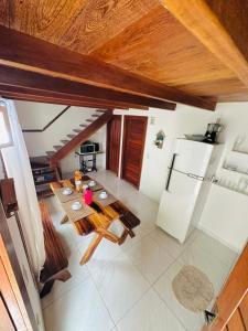 - une vue de tête sur une cuisine équipée d'une table et d'un réfrigérateur dans l'établissement Corumbau Chalé Casa, à Prado