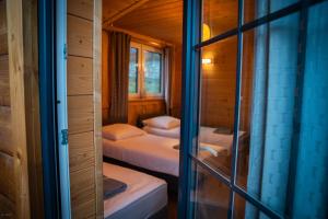 a bedroom with two beds in a wooden cabin at Nebbia Ressort in Karpacz