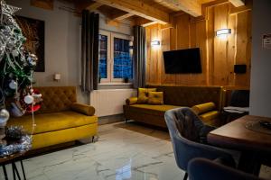 a living room with a couch and a christmas tree at Nebbia Ressort in Karpacz