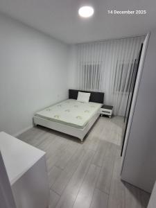 a bedroom with a bed in a white room at Shala apartment in Mitrovicë