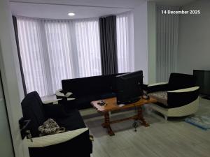 a living room with couches and a television on a table at Shala apartment in Mitrovicë