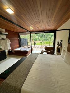 a bedroom with a large bed with a large window at Cabana Terra Nossa com vista in Marechal Floriano