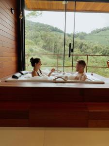 un homme et une femme dans une baignoire dans l'établissement Cabana Terra Nossa com vista, à Marechal Floriano