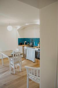 a kitchen with a table and white chairs and a kitchen with blue walls at Apartment mit Connection am Müritz National Park  +22 photos