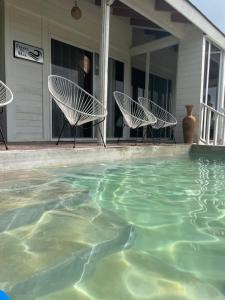 twee stoelen en een zwembad op een huis bij HOLBOX PUERTA DEL MAR in Holbox Island +43 foto's