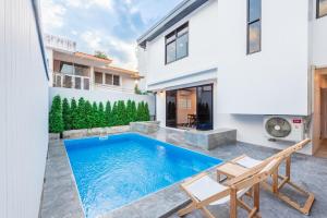 ein Swimmingpool im Hinterhof eines Hauses in der Unterkunft SavasdeeVilla Midtown bangkok in Makkasan