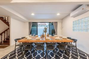 ein Esszimmer mit einem Holztisch und Stühlen in der Unterkunft SavasdeeVilla Midtown bangkok in Makkasan