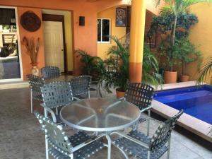 a patio with a table and chairs next to a pool at Hotel Las Salinas in Zihuatanejo