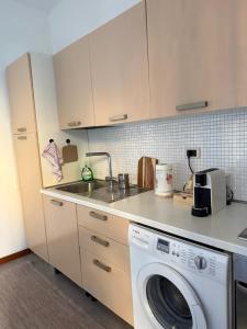 a kitchen with a washing machine and a sink at La Dimora di Siena in Tognazza