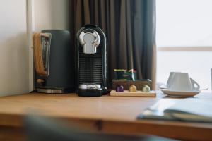 a coffee maker sitting on top of a wooden table at Alpenblick Weggis - Panorama & Alpen Chic Hotel in Weggis