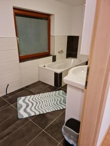 a bathroom with a sink and a tub and a rug at Apart Stefan Niederthai in Niederthai +10 photos