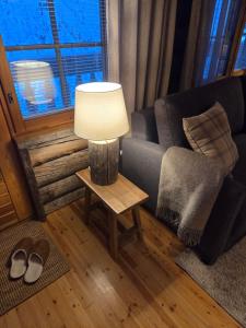 un soggiorno con un divano e un tavolo con una lampada di Kelo Naava a Ruka