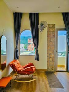 a living room with an orange chair in front of a window at Khách Sạn Trung Loan in Ninh Hải